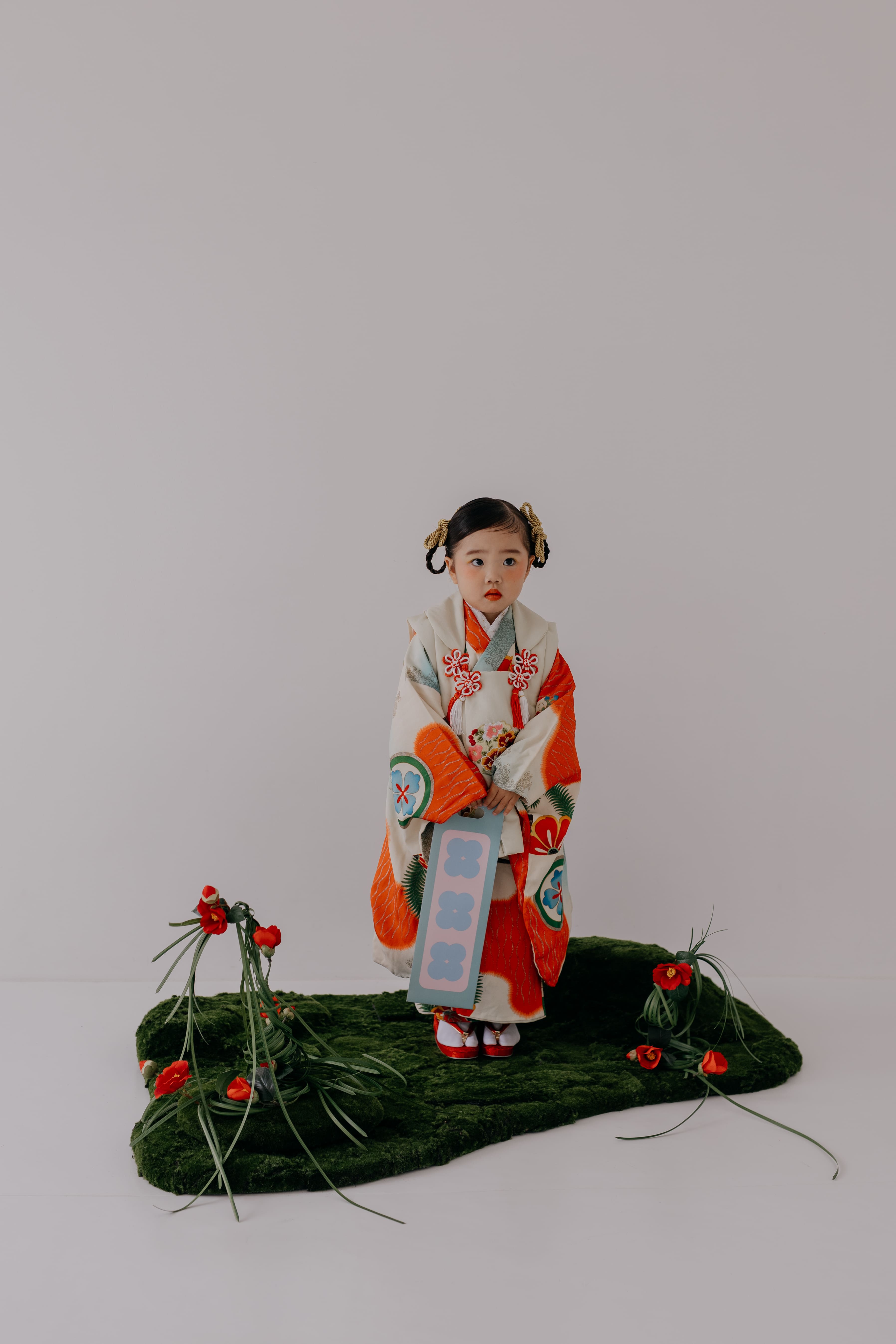 赤い着物に和装の花飾りをつけた女の子の七五三撮影