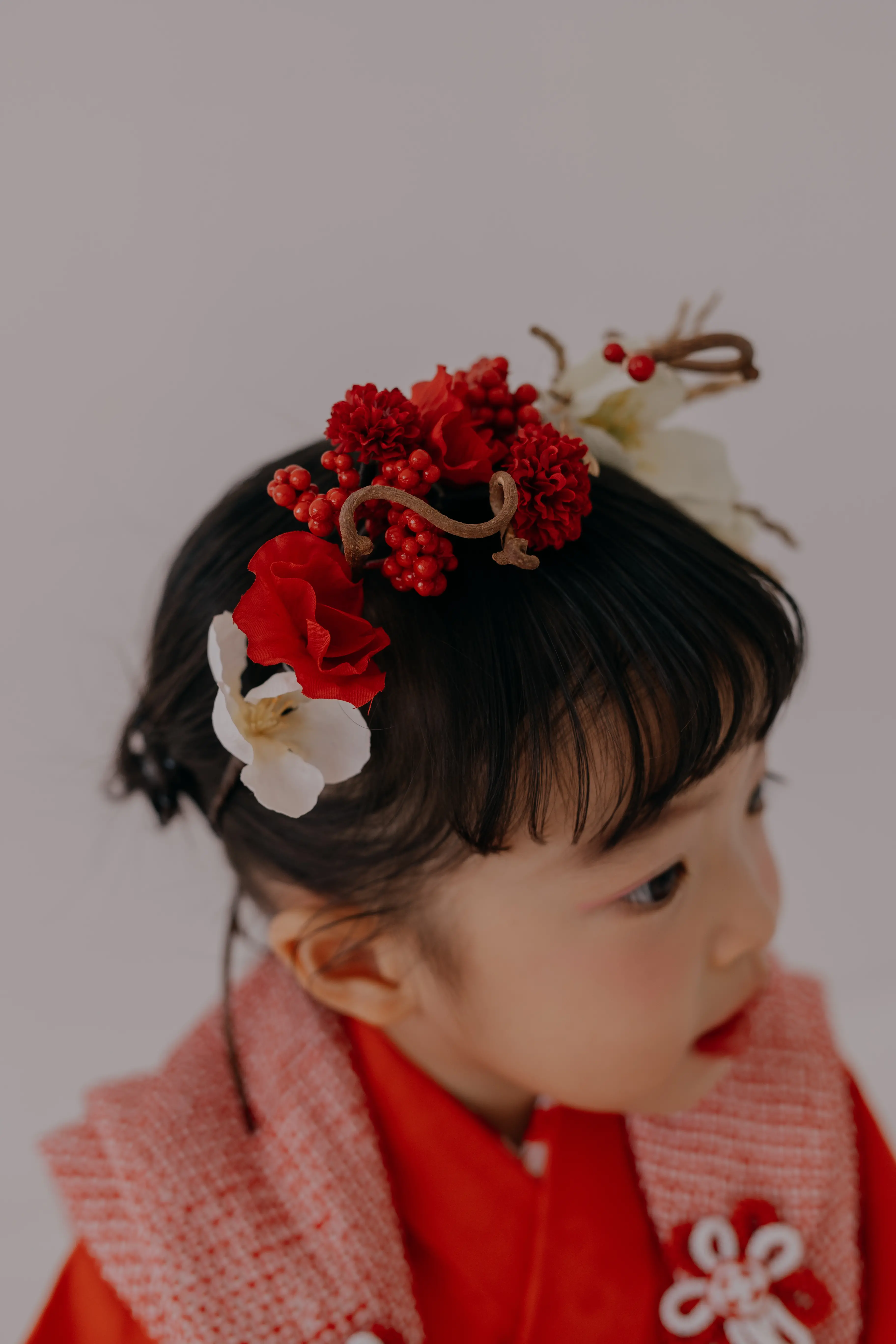 赤い着物に和装の花飾りをつけた女の子の七五三撮影