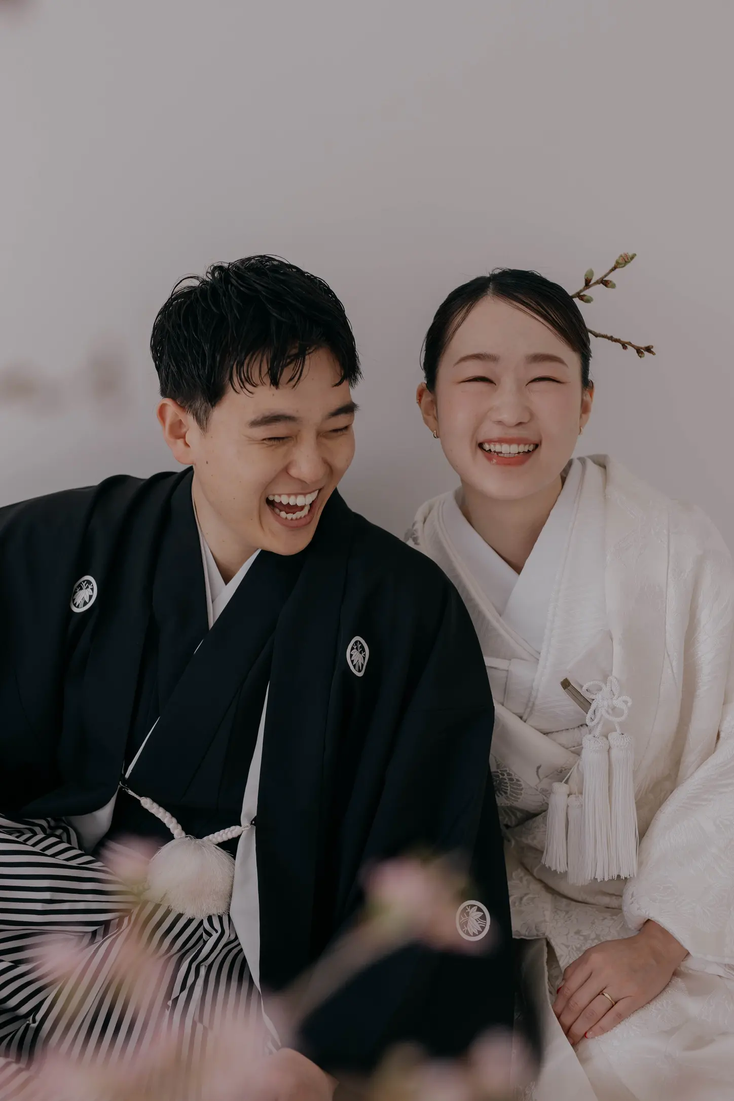 紋付き袴の新郎と白無垢の花嫁が笑い合うクローズアップ写真
